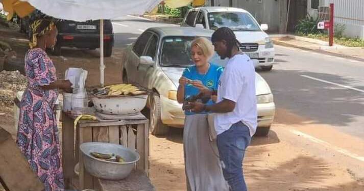 Black Stars goalkeeper Lawrence Ati-Zigi and Swiss Ambassador to Ghana seen getting a roasted plantain on the streets of Accra